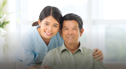 caregiver and a senior man smiling