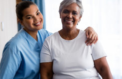 caregiver and a senior woman smiling