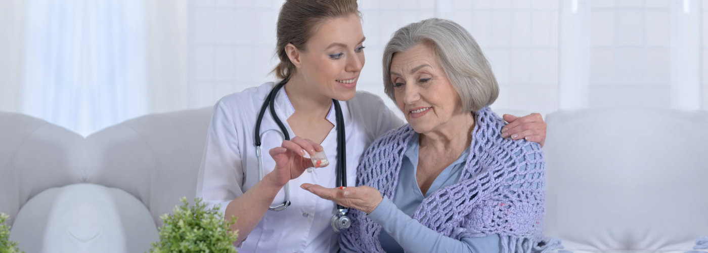 nurse giving her patient her medication