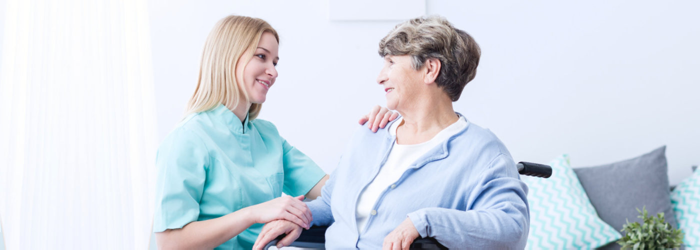 Pretty helpful carer talking with female patient